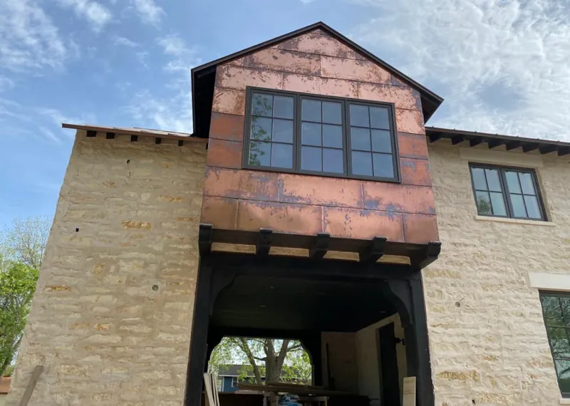 Copper metal panel facade on a stone building for Metal Roof Coating in Black Jack